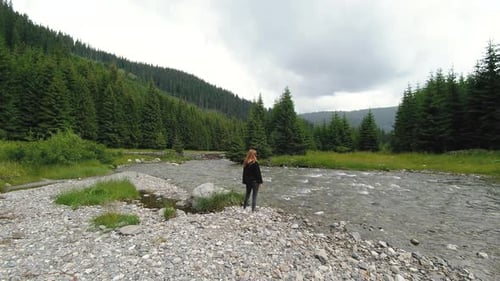 Eine schöne ukrainische junge Reisende geht auf der Transfagarasan- oder Transalpina-Straße um den Fluss