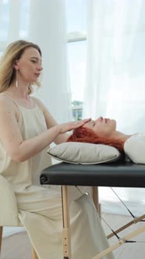 Woman Providing Reiki Treatment for a Woman at Home