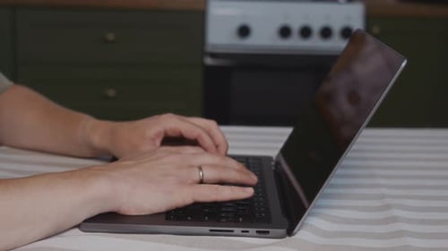 Close Up of Male Hands Typing on Laptop Keyboard in Home Interior