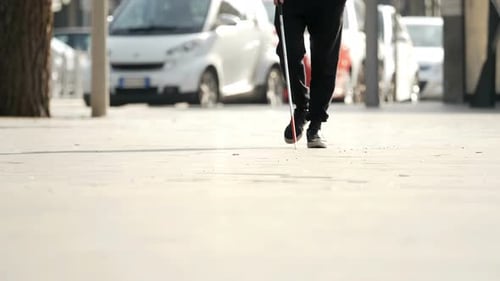 close up on blind man with stick walking in the city.Blindness, autonomy