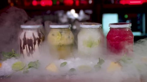 Dry Ice Reveal Of Colourful Frozen Smoothie Jars On Bar. Dolly Forward, Slow Motion
