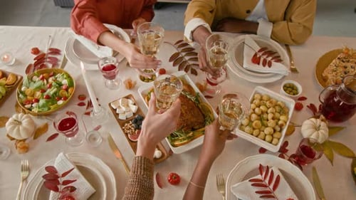Festive Friends Gather Around Thanksgiving Dinner Table