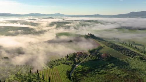 Aerial view of rolling hills with fog, Tuscany, Italy.