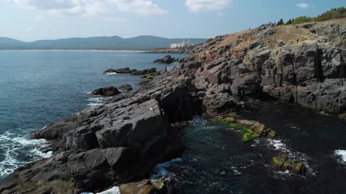 Luftaufnahme von großen Felsen im Meer neben der Küste im sonnigen Sommer
Tag