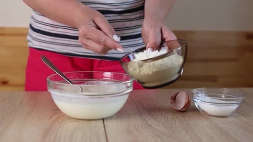 Woman Baking Adding Ingredients to Batter Indoors