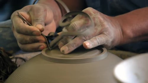 Worker in pottery studio using pottery wheel, handmade ceramics.
