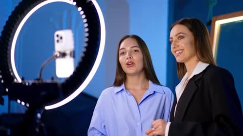 Two Young Women Filming Video with Ring Light