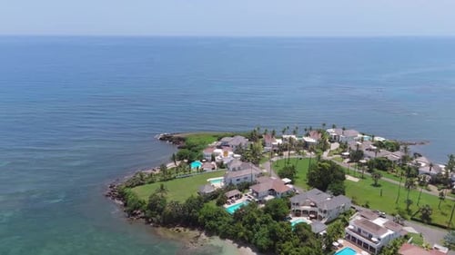 Vista aérea de los tejados de los complejos vacacionales con vistas a una playa de arena tropical y un mar azul
