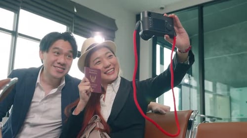 Happy Couple Takes Pictures at Airport Before Flight