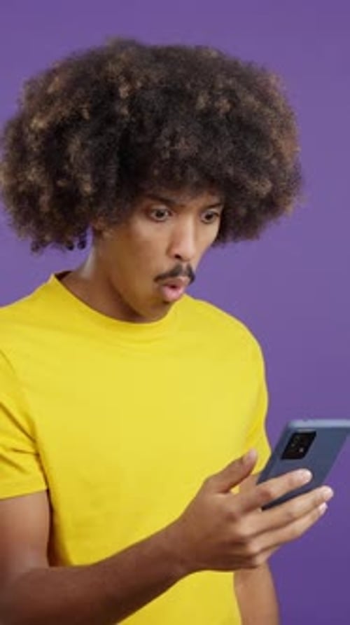 Surprised Man Looking at Phone on Purple Background