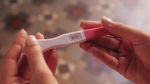 Hände haltender Schwangerschaftstest, der sich dreht, um eine Zeile zu zeigen, negativer Test, Problem, Familienplanung