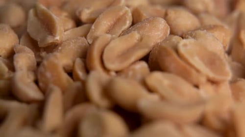 Salted peanuts snack food on the table. Track out background. Salted and roasted peanuts seeds.