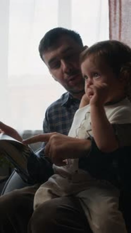 Father reading a book to his young child