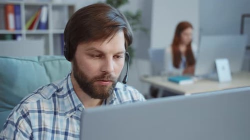 Man with Headset Working at Computer in Office