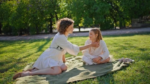 Woman and Child Sitting in Grassy Field