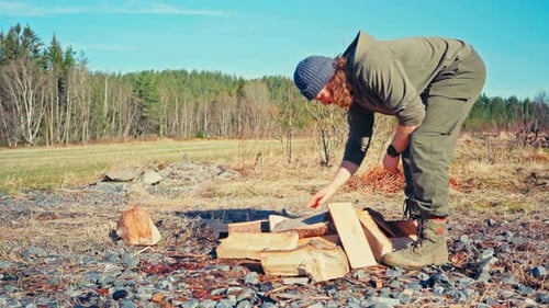 A Man is Getting Ready to Burn Freshly Cut Firewood - Close Up