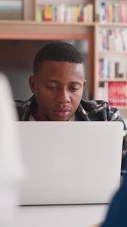 Young Adult Works on Laptop Indoors