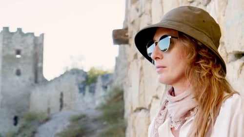 Woman Gazing at Castle Ruins on Sunny Day
