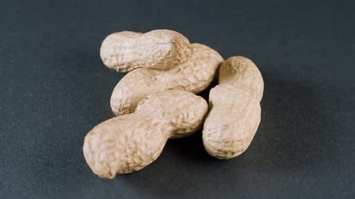 Close-Up of Fresh Peanuts on Dark Surface