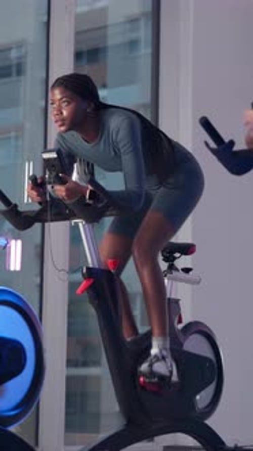 Fitness, spin class and woman on bike in gym for exercise, cardio workout and cycling for wellness