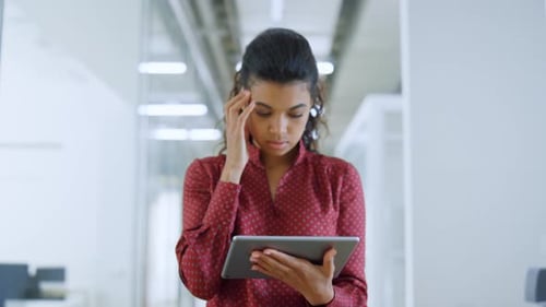 Upset African Woman Receiving Message on Tablet in Modern Office. Disappointed Girl