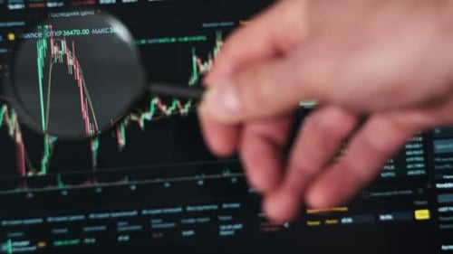 Close Up of Stock Market Analysis with Magnifying Glass