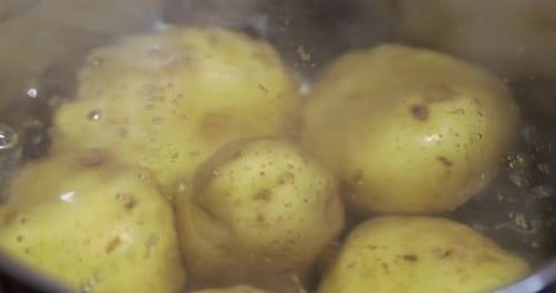 Nahaufnahme von rohen Kartoffeln in kochendem Wasser