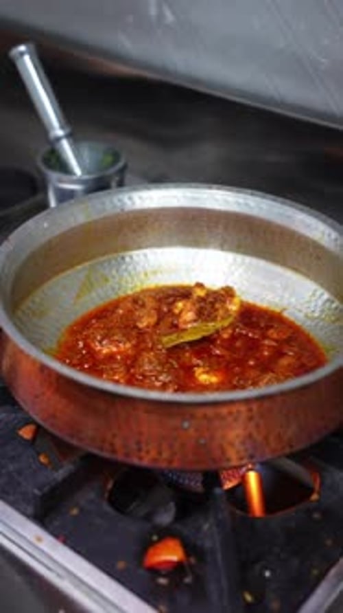 Curry de camarão fervendo em panela de metal