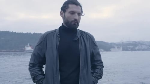Closeup of stressed man standing on the coast of the ocean in slow motion