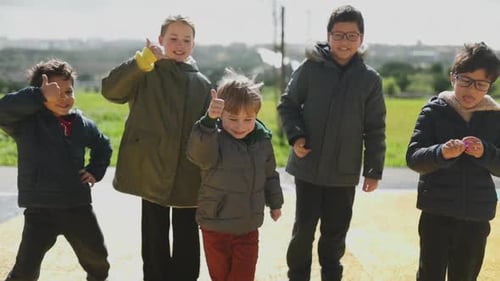 Group of Children Give a Thumbs Up Outdoors