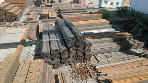 Vista aérea de la pila de tubos de hierro galvanizado y barras rectangulares de acero de metal