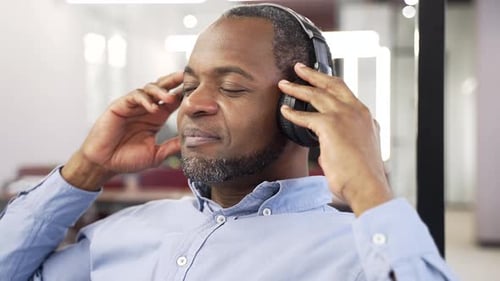 Man Relaxes with Headphones in Modern Office