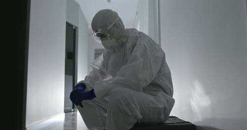 Health Worker in Protective Suit Resting