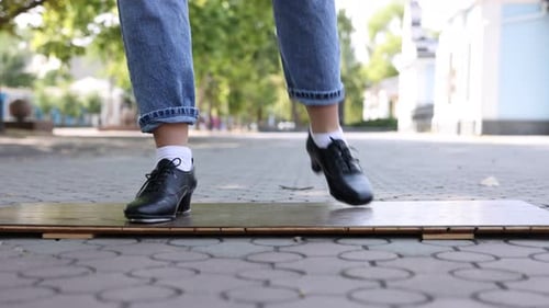 Teenage girl in tap shoes dancing outdoors, closeup