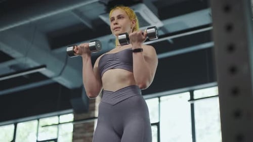 Gorgeous Female Professional Bodybuilder Doing Workout Exercises in Gym