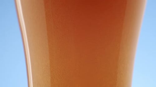 Pouring Beer into Glass with Bubbles and Foam
