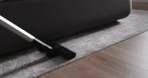 Close Up of Vacuum Cleaner Vacuuming Carpet in Modern Apartment House Cleaning Concept