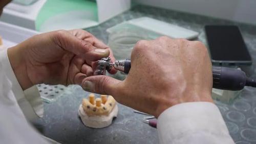 Dental Technician Carving a Bridge Restoration