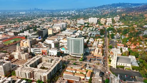 Sunny view of dense urban landscape with lively traffic on the roads. Panorama of Los Angeles hills