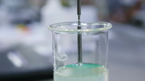 Close View Metal Tube Put Into Clear Slime in Lab Beaker