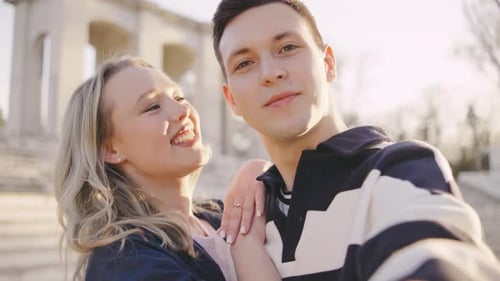 POV Couple Enjoying a Joyful Moment During Sunset at a Historic Park Sharing a Sweet Kiss and Smiles