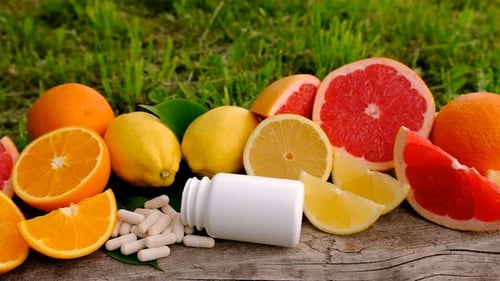 Fresh Citrus Fruits and Vitamin C Supplements