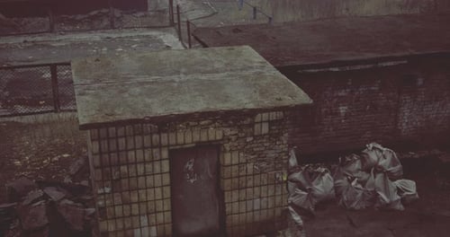Old Abandoned Structure Surrounded By Debris in a Desolate Area During Daytime