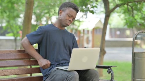 Young Adult Working on Laptop With Back Pain