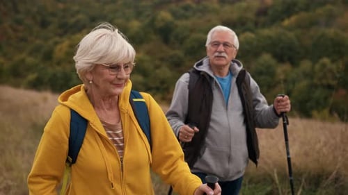 Senior Couple Hiking Together in Grassy Countryside