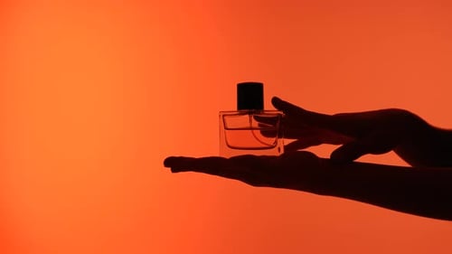 Silhouette of Hands Holding a Perfume Bottle