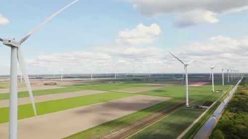 Wind Turbines Spinning on Green Fields on Sunny Day