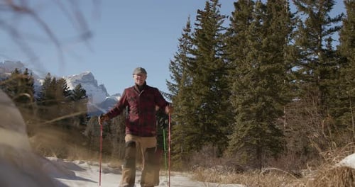 Senior Couple Hing in Sunny Snowy Mountain Woods Active Seniors