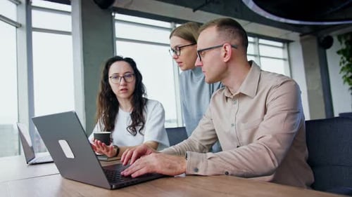 Office team looking through the information on laptop.
