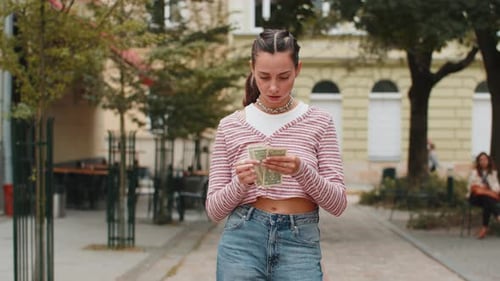 Poor Young Woman on City Street Holding One Dollar Banknotes Lack of Money to Buy Purchase Something